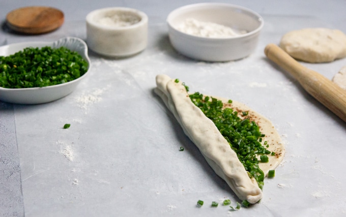 Chinese scallion pancakes being rolled up