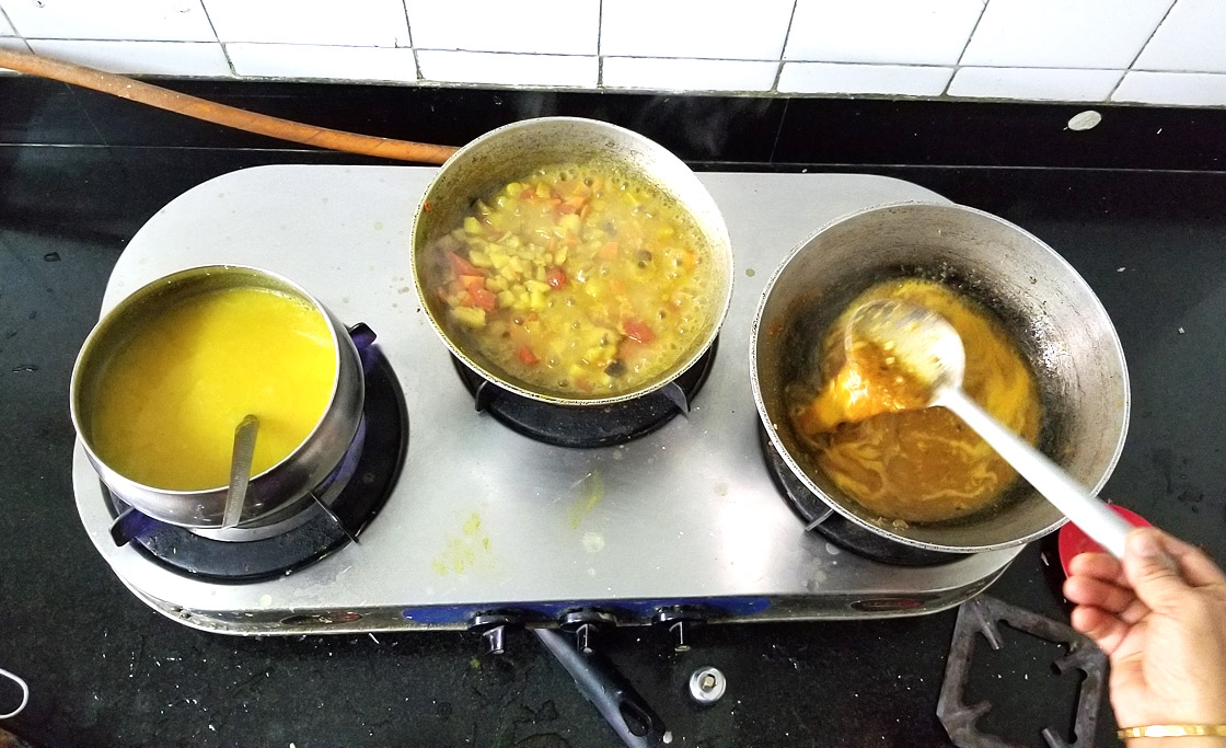 Pots on Amma's stove. Each pot (lentils, diced vegetables, and tamarind), will be combined to make South Indian kootu. 