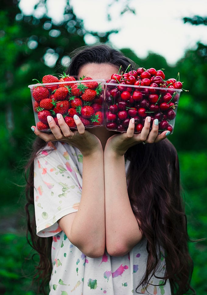a woman balances baskets of berries